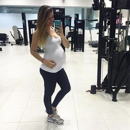 Pregnant young girl in a swimsuit gym..